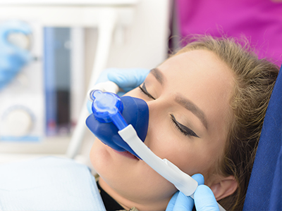 A woman receiving medical care with an oxygen mask over her face.